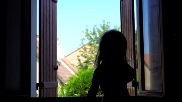 Silhouette d'une fille aux cheveux longs saute sur le fond d'une fenêtre ouverte — Video