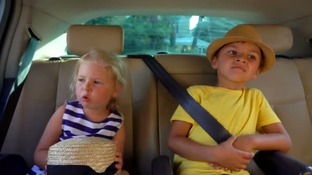 Kleine jongen en meisje rijden in de auto en praten met elkaar. — Stockvideo