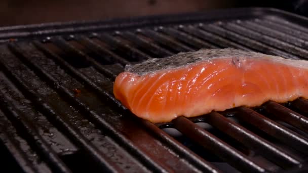 A piece of delicious salmon fillet steak is frying on the grill — Stock Video