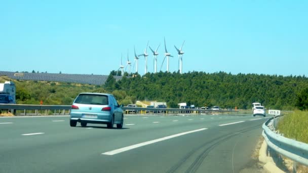 Autostrada con campo con pannelli solari per la produzione di energia pulita sullo sfondo — Video Stock