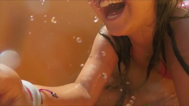 Chica de pelo negro está montando por un tobogán naranja en su estómago — Vídeos de Stock