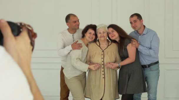 Fotograf fotí bělovlasou ženu se svými vnoučaty