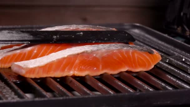 Cocinar presionar un trozo de filete de salmón con espátula negra a la parrilla — Vídeo de stock