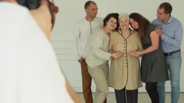 Фотограф фотографирует пожилую женщину со своими внуками — стоковое видео