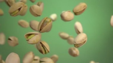 Çapraz uçan fıstıkları yakın çekim yavaş çekimde yeşil arka planda