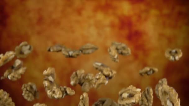 Peeled walnut nuts are bouncing on a yellow ochre background — Stock Video