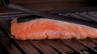 Pişir bir parça çiğ somon fileto biftek ve siyah spatula.