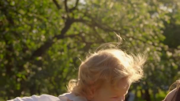 Moeder is kotsen en knuffelen haar kleine schattige dochter in witte jurk — Stockvideo