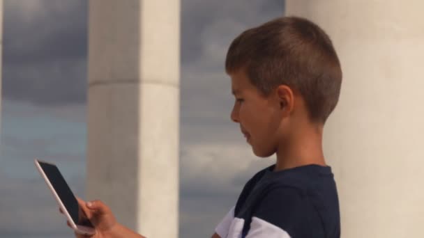 陽気少年は彼の手の中に電話で見ていると自画自身を作る — ストック動画