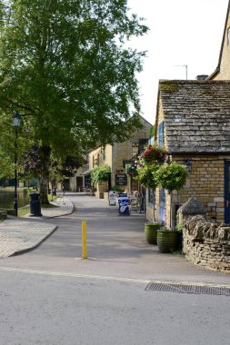 Bourton On Water, İngiltere - 21 Haziran 2017: Sabah erken ana cadde ve nehir Windrush, su üzerinde Bourton, Gloucestershire, Cotswolds, İngiltere'de, İngiltere'de boyunca görüntülemek
