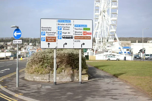 Weston-Super-Mare, İngiltere-18 Mart 2018: Weston-super-mare seafront, Weston tekerlek yön-e doğru çeşitli yerlerde, Weston-super-mare, Somerset, İngiltere'de gösterilen bir yol işareti ile arka planda görülebilir