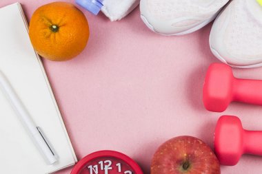 Spor ayakkabı, halter fitness, pembe bir arka plan. Sunuluyor