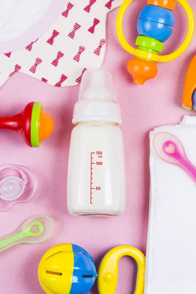 婴儿用品。木制玩具, 奶嘴和粉红色 backg 瓶 — 图库照片