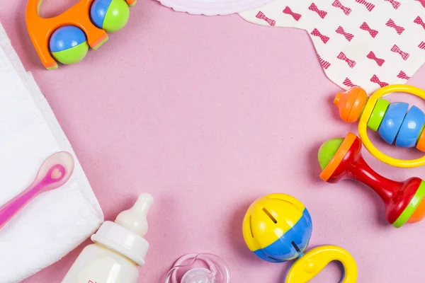 Bebek aksesuarları. Ahşap oyuncak, emzik ve biberon pembe backg üzerinde