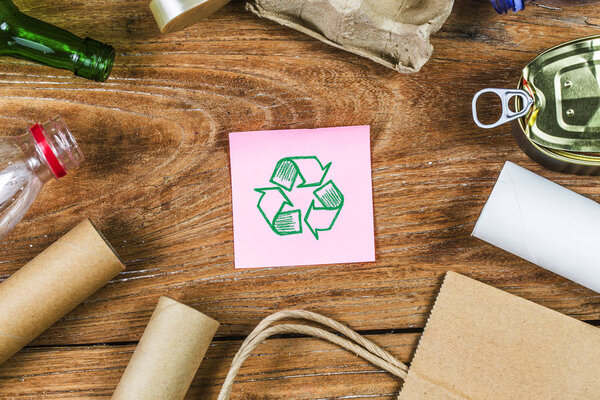 экологический символ утилизации отходов с вывозом мусора на деревянный стол
