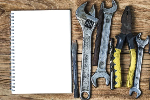 Olika verktyg och den tom anteckningsboken på en trä bakgrund — Stockfoto