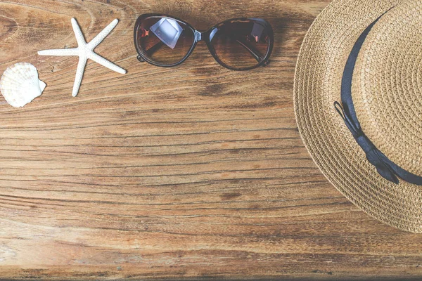 Sombrero de paja y gafas de sol sobre madera — Foto de Stock