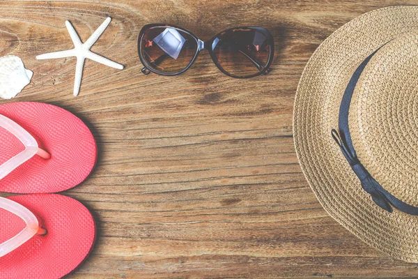 Sombrero de paja y gafas de sol sobre madera — Foto de Stock