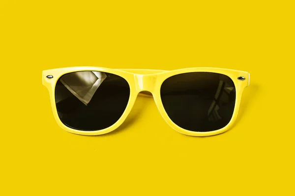 Óculos amarelos em um fundo amarelo, óculos de sol — Fotografia de Stock