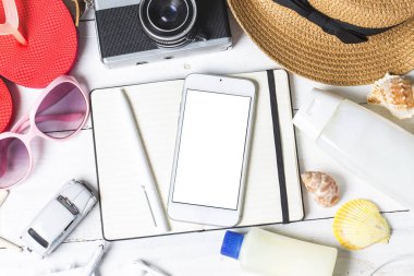 Plaj aksesuarları. Çanta, havlu, güneş gözlüğü ve ahşap arka plan üzerinde parmak arası terlik. Kopya alanı ile Üstten Görünüm