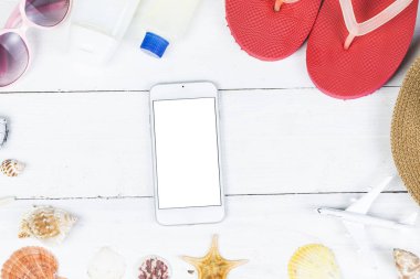 Plaj aksesuarları. Çanta, havlu, güneş gözlüğü ve ahşap arka plan üzerinde parmak arası terlik. Kopya alanı ile Üstten Görünüm