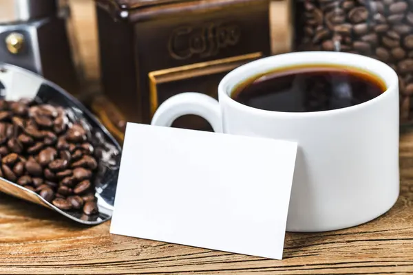 Blank business cards and cup of coffee on wooden table. Corporate stationary branding mock up.
