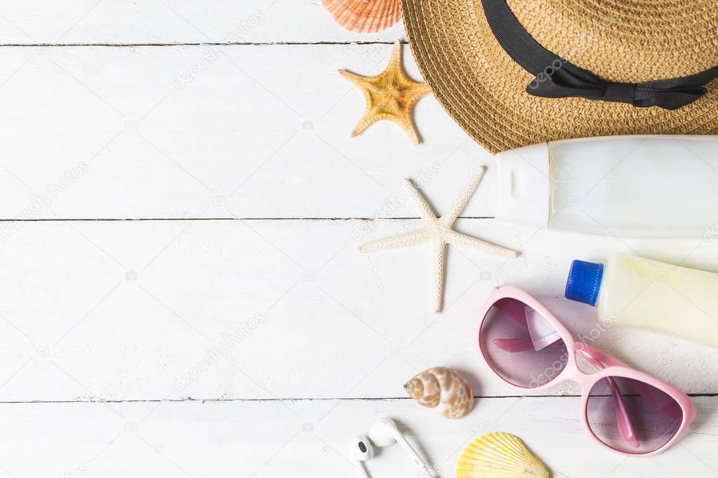 Beach accessories. Bag, towel, sunglasses and flip-flops on wooden background. Top view with copy space