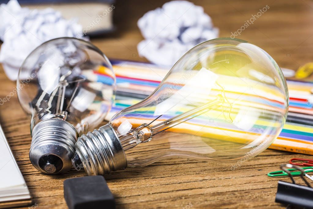 great idea concept with crumpled office paper and light bulb standing on table