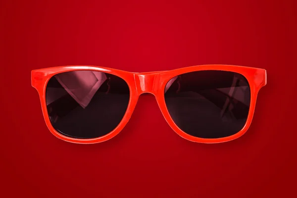 Red sunglasses on red background