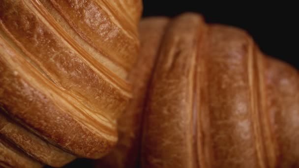 Fresh croissants on black background. Blur effect. Close up view — Stock Video