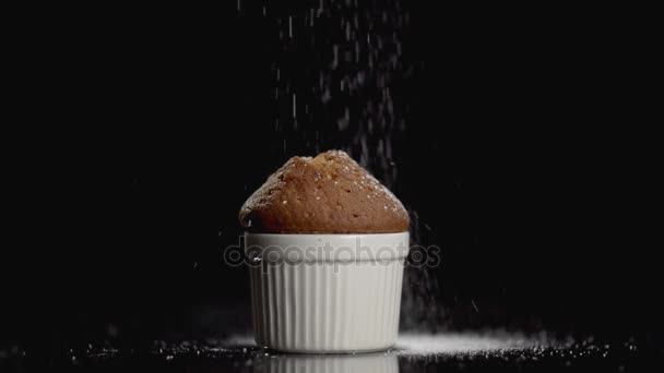 Muffin cake met poedersuiker op donkere achtergrond met copyspace. Slow motion — Stockvideo