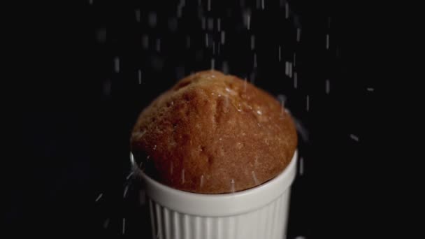 Muffin ciasto z białym cukrem pudrem na ciemnym tle. Zwolnionym tempie. Z bliska — Wideo stockowe