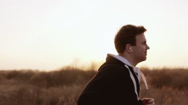 Gün batımı açık havada siyah kapşonlu kazak yalnız oyundaki. Ağır çekim