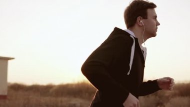 Gün batımı açık havada siyah kapşonlu kazak yalnız gülen oyundaki. Ağır çekim