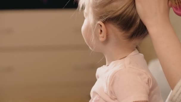 Mère fait coiffure fille à l'intérieur. Coup 4k — Video