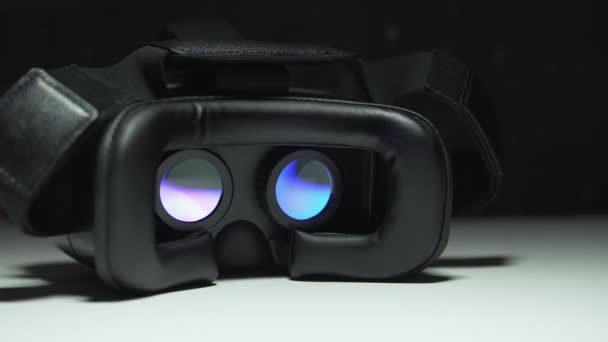 Filme jogando dentro do dispositivo de realidade virtual à noite na mesa branca. 4k UHD — Vídeo de Stock