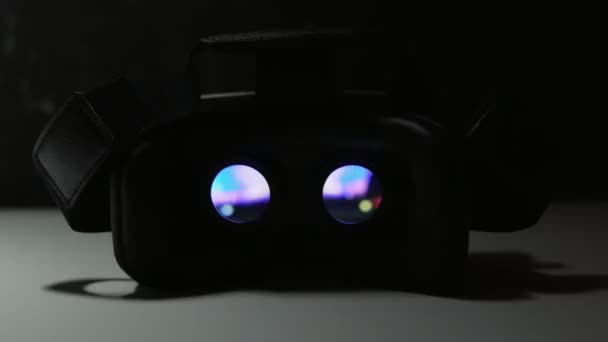 Jouer un film à l'intérieur d'un appareil de réalité virtuelle sur une table blanche la nuit. 4k UHD 