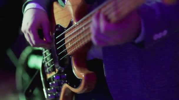 Bass Guitar fechar. Um homem a tocar guitarra no concerto de rock. 4k UHD de vídeo — Vídeo de Stock