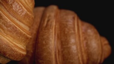 Siyah arka plan üzerine taze kruvasanlar. Sola kaydırın. Görünümü kapatın