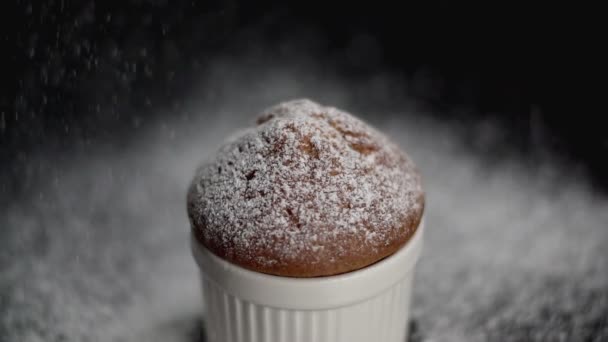 Gâteau muffin avec sucre blanc en poudre sur fond sombre. Au ralenti. Gros plan — Video