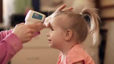Anne kızı kapalı 4 k dijital termometre kullanarak sıcaklık alarak