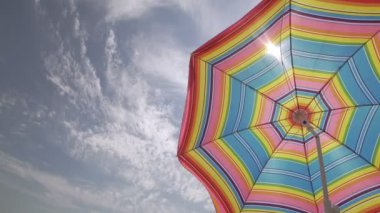 Güneş şemsiyesi, gökyüzü arka plan güzel güneşli havalarda sallayarak. Boşaltmak sol