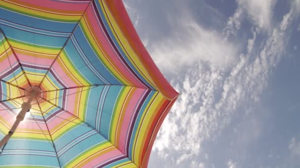 Сонячна парасолька махає в гарну сонячну погоду на фоні неба. Копіювати простір праворуч — стокове відео