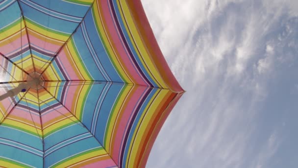 Солнечный зонтик машет в хорошую солнечную погоду на фоне неба. Копировальное пространство справа — стоковое видео