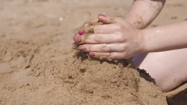 Primer plano de la torre de arena. Chica hace castillo de arena. UHD 4k — Vídeos de Stock