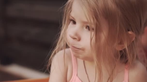 Klein meisje haar mond vanwege iets lekker, drankje concept likken — Stockvideo