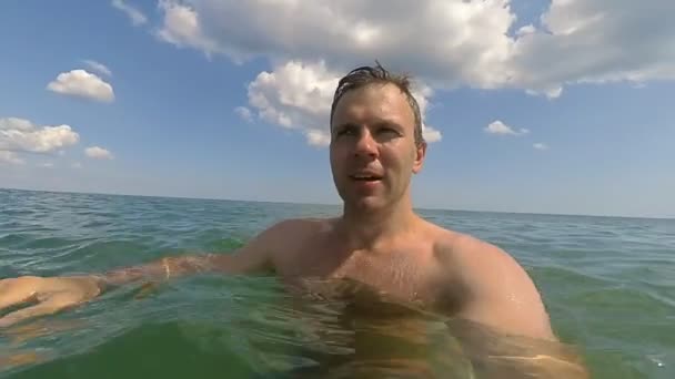 Jeune homme sportif faisant du selfie en mer et plongeant sous l'eau au ralenti — Video