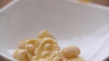 Mısır gevreği beyaz kase yavaş düşüyor. Görünümü kapatın