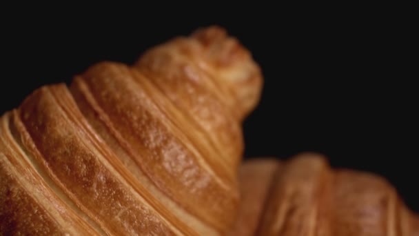 Verse croissants op zwarte achtergrond. Schuif naar beneden. Close-up — Stockvideo