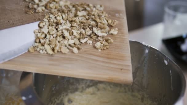 Hornear un pastel - añadir ingredientes al tazón. Añadir las nueces a la masa en cámara lenta — Vídeo de stock